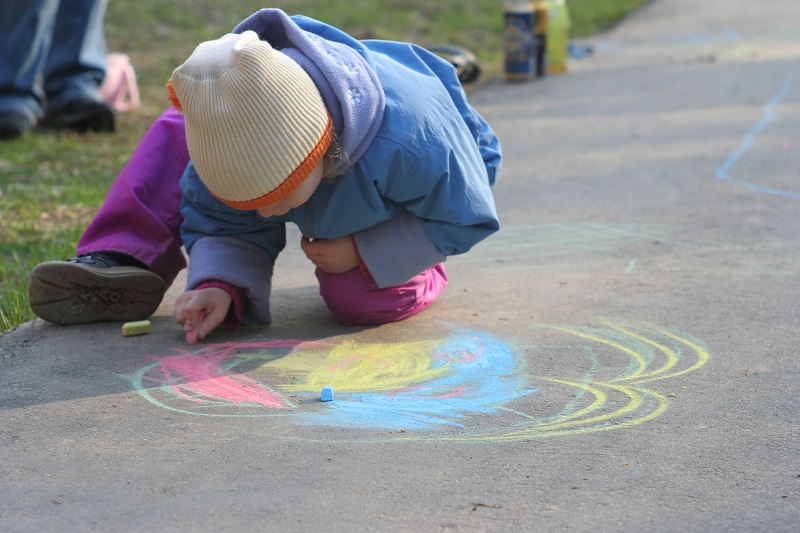 Child drawing on sidewalk